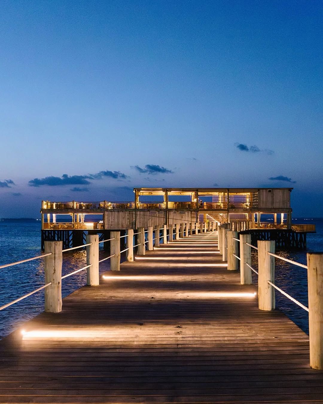 JAZ Aurora pier illuminated at night above the ocean